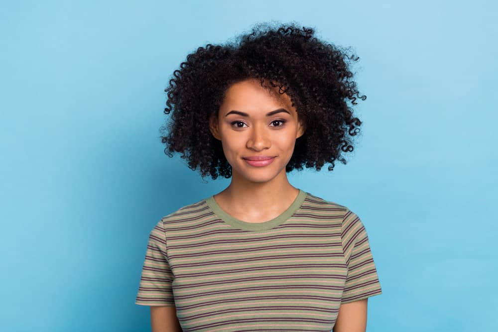 Cute African American female with healthy hair growth wearing hair extensions on her fine hair to create fullness.