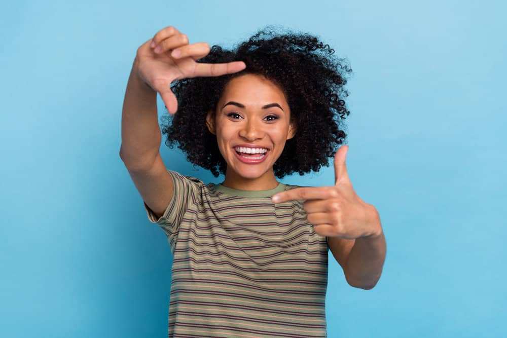 Cute black woman with hair shaft damage after using harsh chemicals on her kinky hair strands.