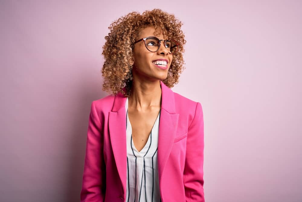 Young African American professional with bouncy curls colored with demi-permanent hair dye with conditioner.