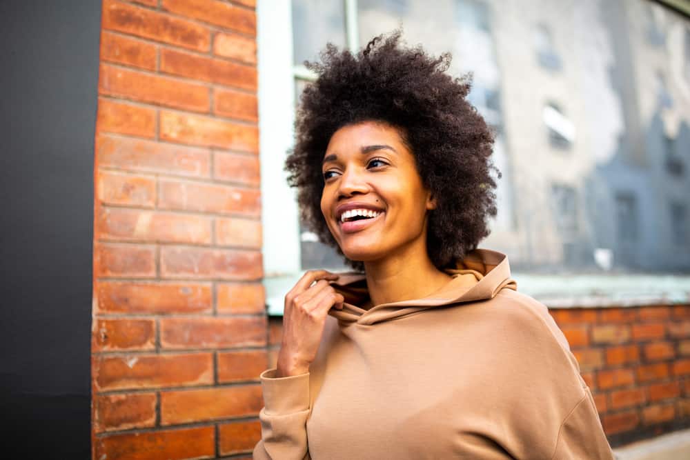 Light skinned black woman with gorgeous hair wearing a wash-n-go style created with a wide-toothed comb.