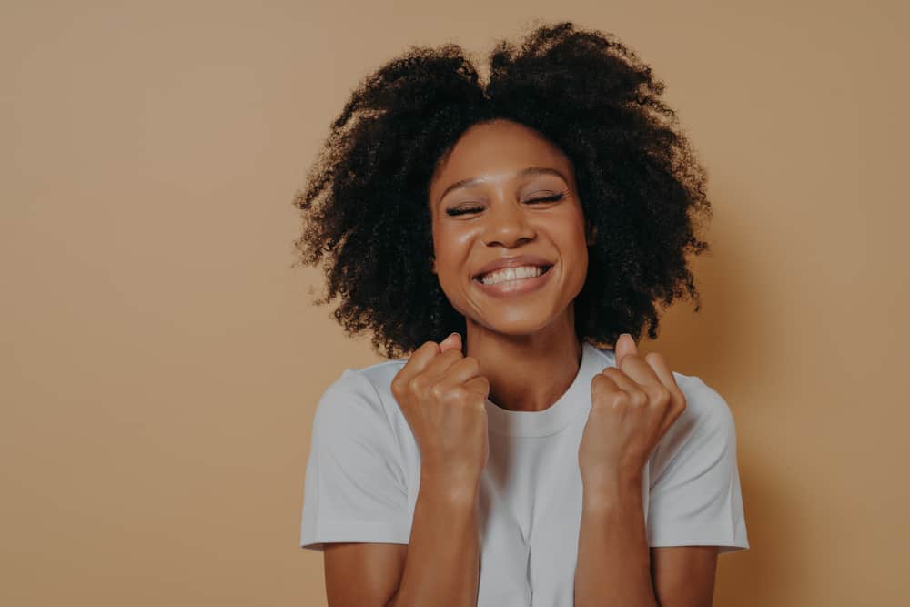 Young African American female with an uneven natural curl pattern due to getting the wrong haircut.