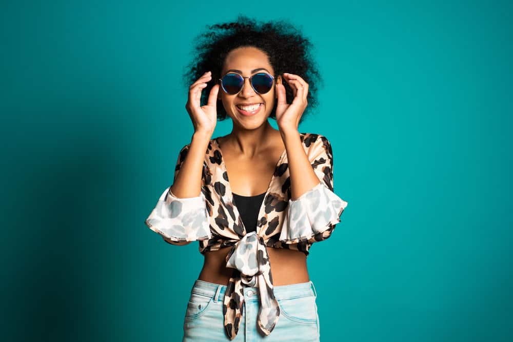 A black girl with a wavy hair structure with dark brown colored hair treated hair styled with anti-frizz hairspray.