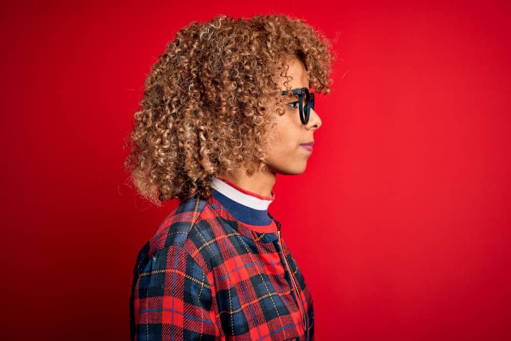 African female with short hair wondering why her bleached hair grows slower after several bleaching sessions.