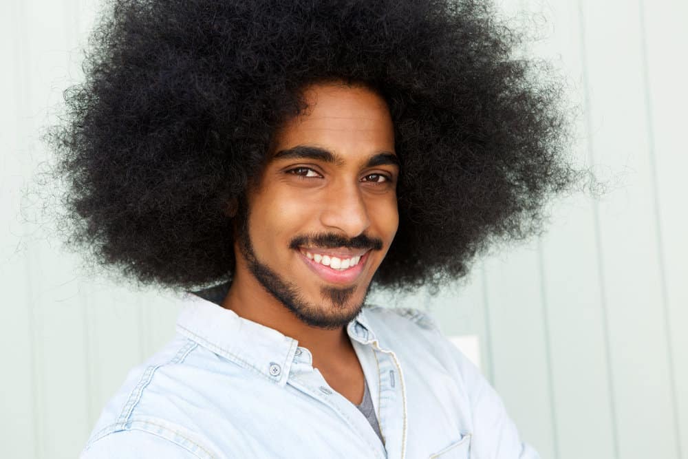 Light-skinned African American with thinning hair loss before growing a big afro with a rebellious edge.