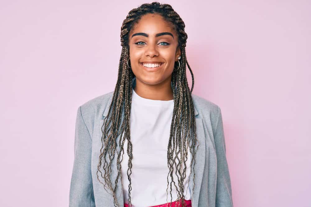 Cute African American lady wearing longer hair due to rocking a new hairstyle with braiding hair.