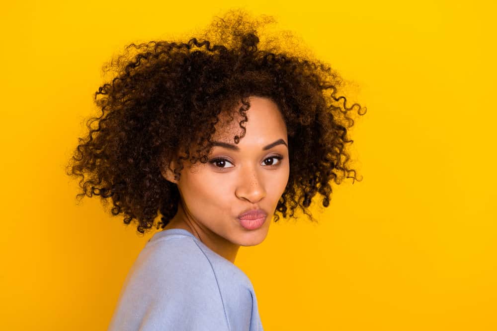 A young light-skinned black girl with totally smooth hair cuticles after using Cardi's DIY mask with argan oil.