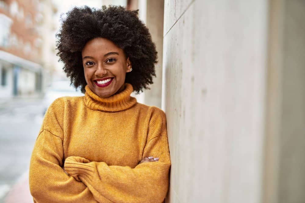 Young African American lady with emerging grey hair that interested in gray blending her silver strands.