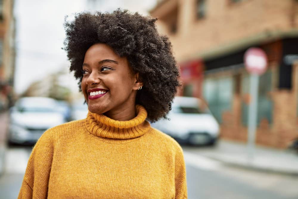 Cute young black girl walking through the city with a dark brown natural color that is interested in blending gray hair.