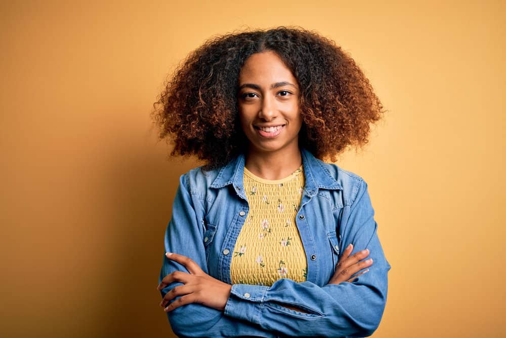 Cute young African American female with permanent hair color on her unwashed hair strands.