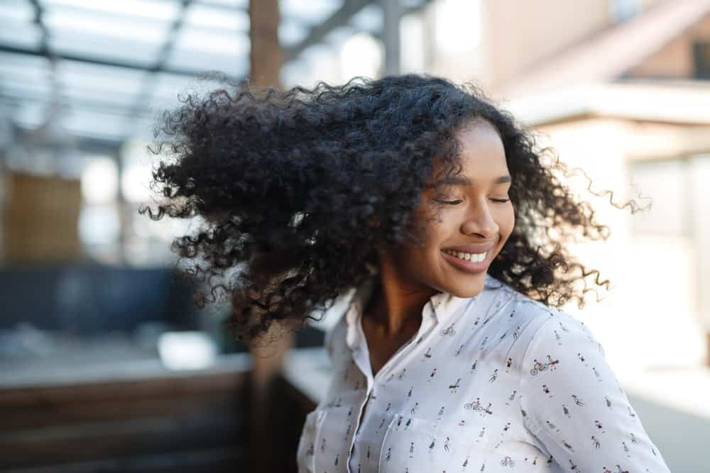 A black female with healthy hair after washing hair with a DIY mix - castile soap and baking soda to eliminate oily hair.