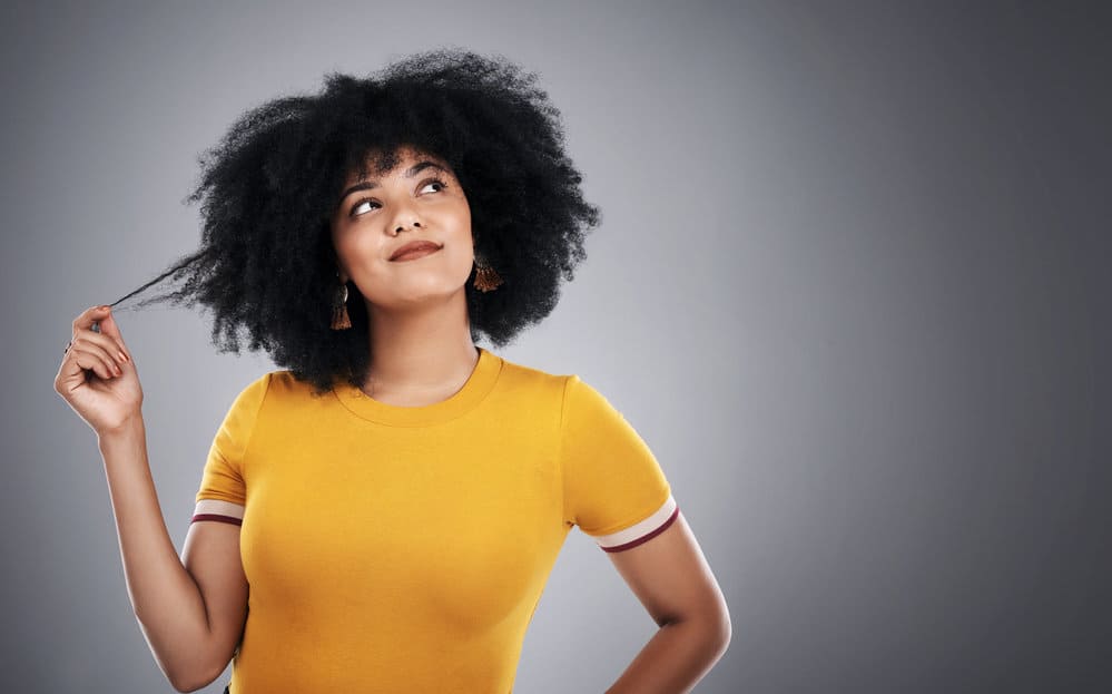 A lovely young light-skinned woman with golden brown natural curls caused by eumelanin pigment.