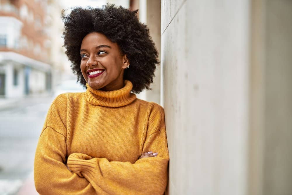 A cute young black woman with dark hair wants to use purple shampoo on her dark brown hair to tone it.