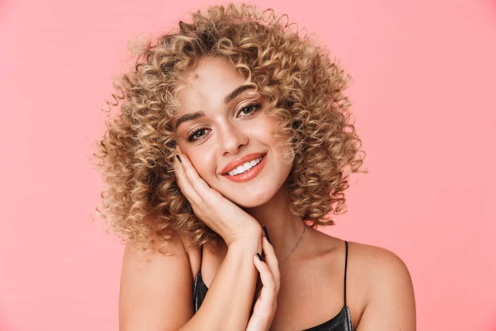 Gorgeous woman with choppy bangs on a sophisticated haircut with natural waves and curls.