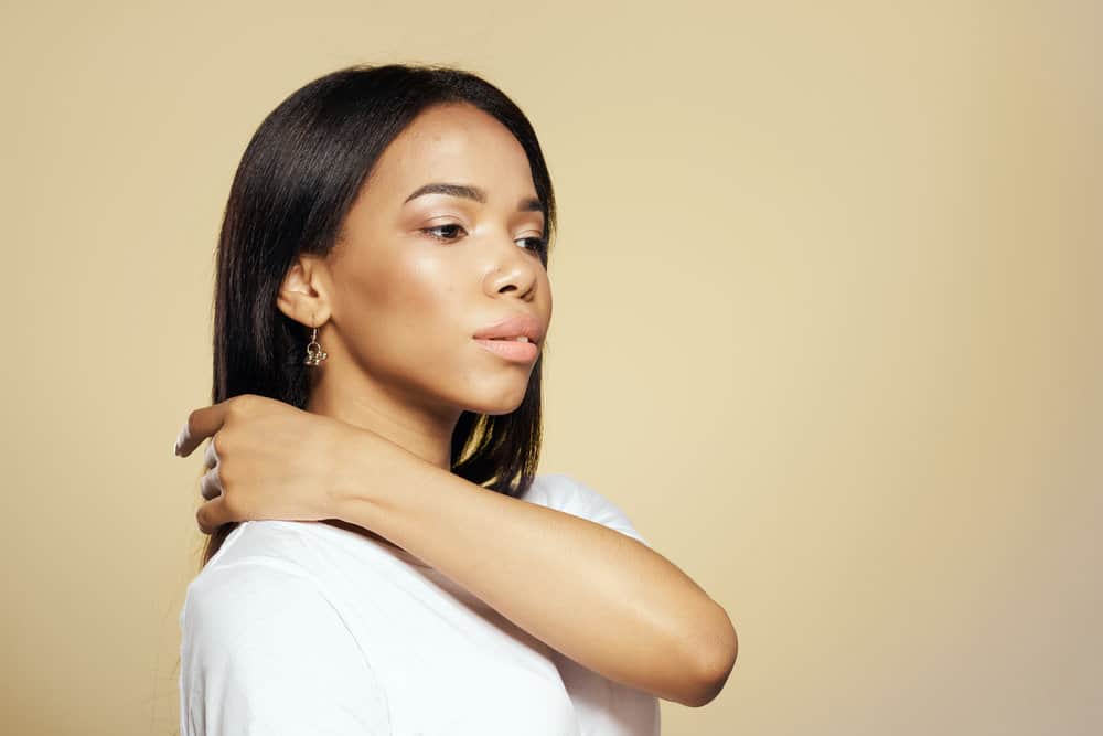 A young, light-skinned African American girl with dry hair after flat ironing her wet hair.