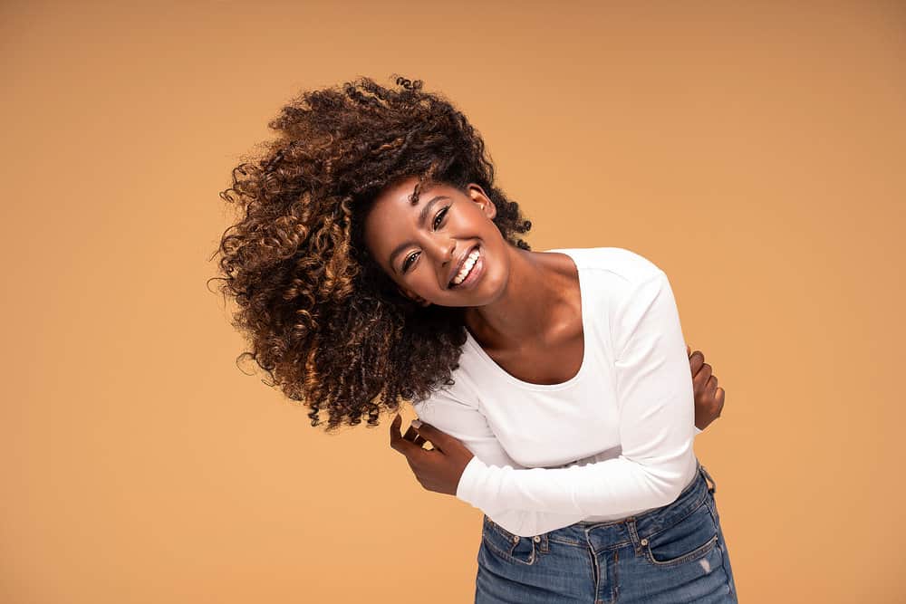 A black woman wearing a cute laid-back style that's the perfect length for her casual white shirt and blue jeans.