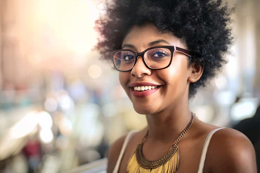 Cute African American female leaving a local salon after getting her hair styled by a professional hairdresser.