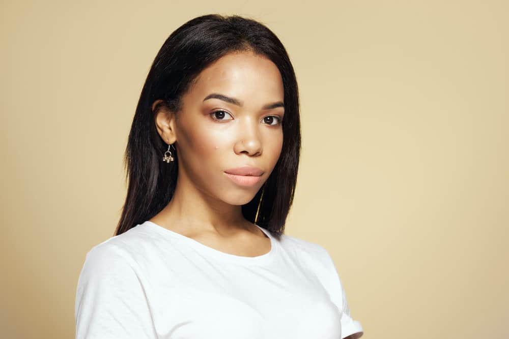 A black female with straight hair after using a heat protectant spray as a protective barrier to straighten her hair.