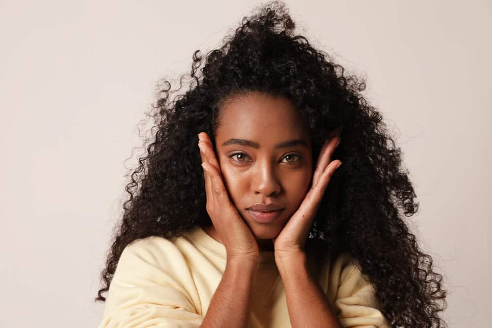 Cute African American female with a 3B hair type showing off her curls after drying her wet hair.