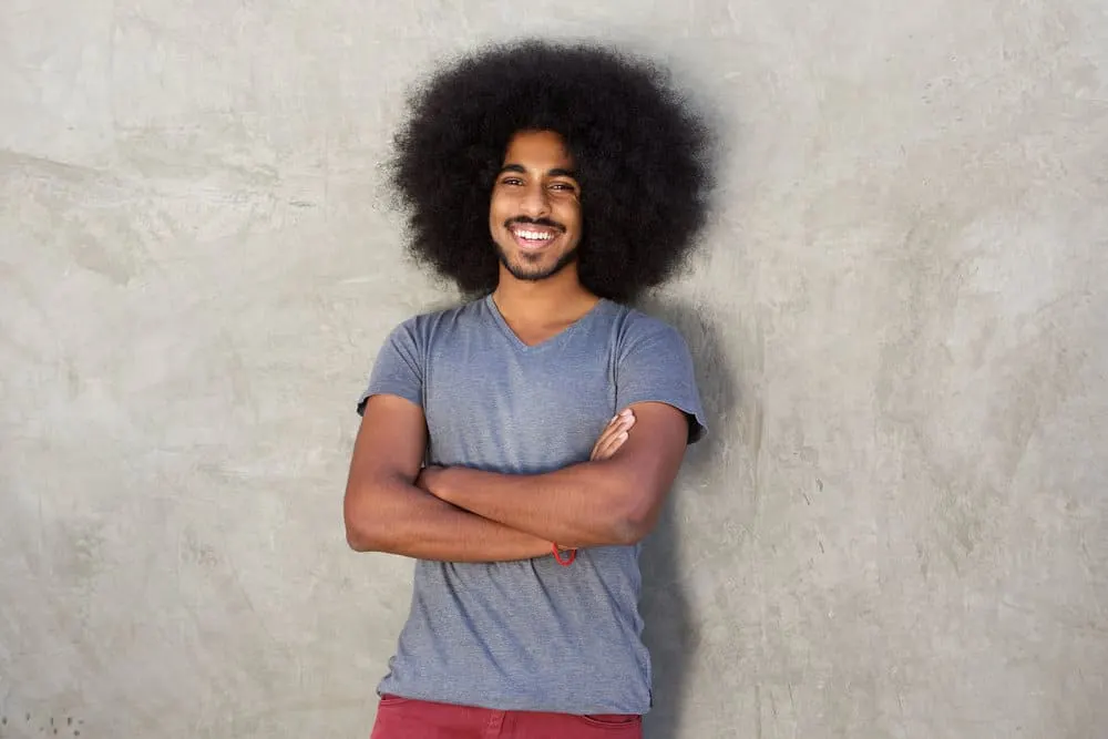 What Long Hair Says About a Man? What Does It Symbolize? 4 Adult male with his arms crossed wondering if females find long hair attractive as he prepares for his first date.