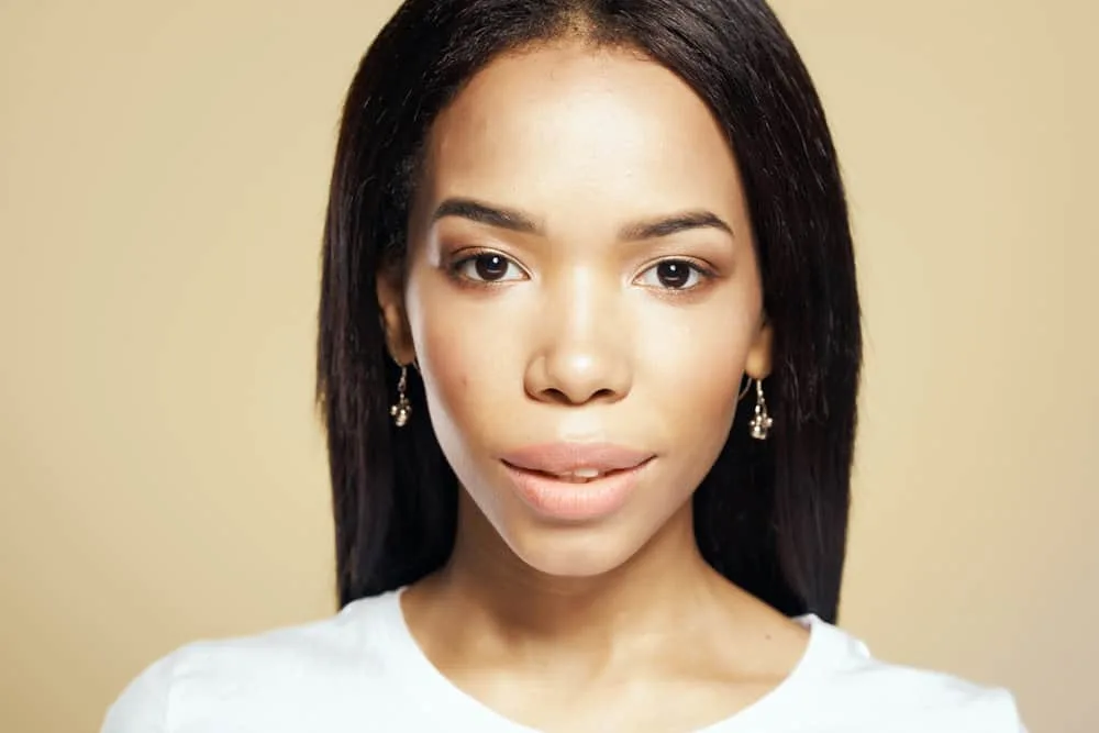 How Long Does Heat Protectant Last on Hair After Applying It? 1 A pretty African American female with flat ironed natural hair styled with a heat protection spray.