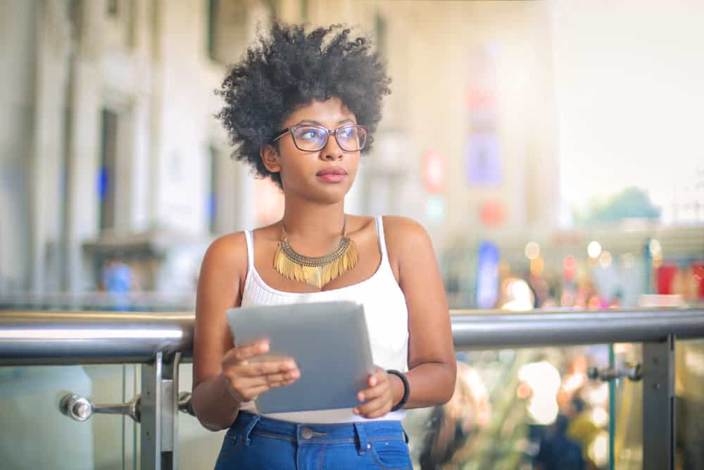 Young black lady reviewing services offered and prices at Great Clips to confirm current pricing of haircare products.