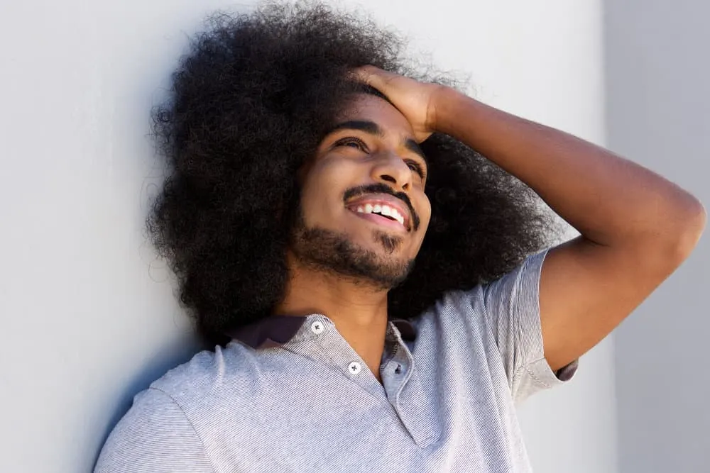 Young man laughing after considering his cultural identity after growing long hair affected his self-esteem.