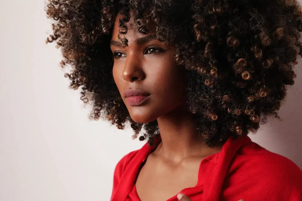 An attractive black woman with big curls with a unique smell giving off a lovely general scent.