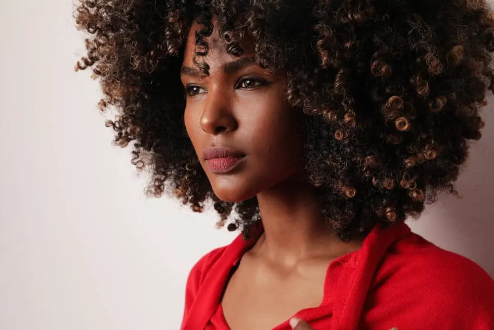 What Does It Mean When a Guy Smells Your Hair? Does He Like You? 3 An attractive black woman with big curls with a unique smell giving off a lovely general scent.