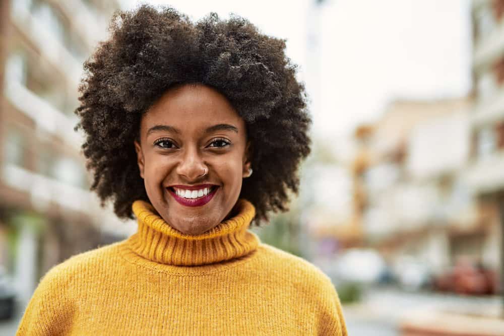 Cute young black girl with dark hair wanting to dye her curls a dark brown shade because she's getting gray hair.