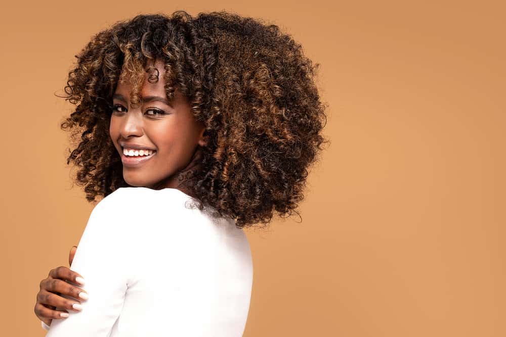 Beautiful African American woman wearing a trending haircut with long bangs that are bottleneck shape.