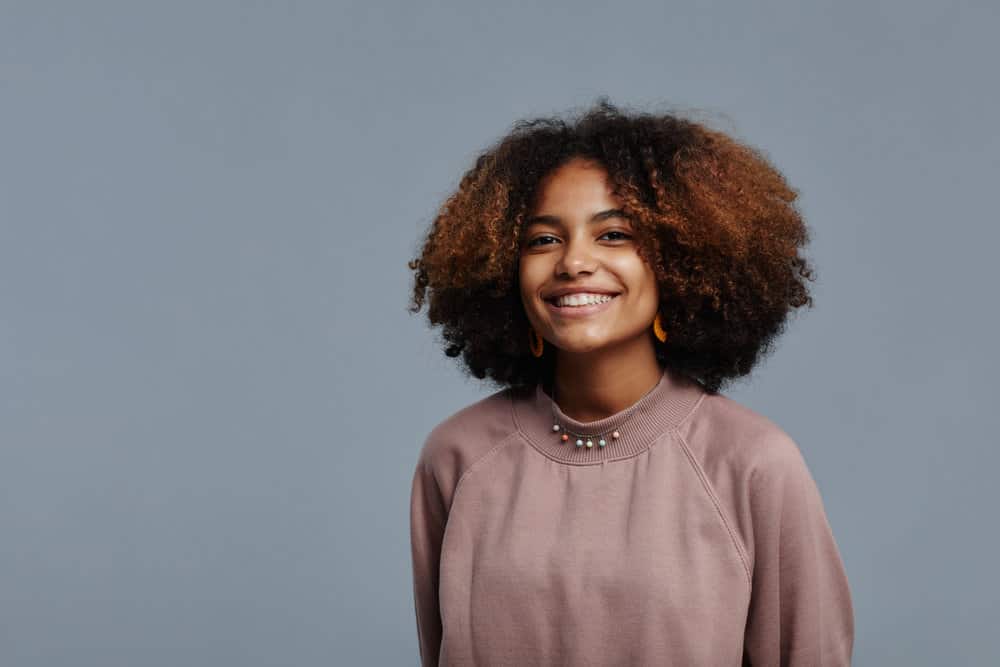 Young black girl showing off her 3B curls after using a thawed shampoo and conditioner bottle.