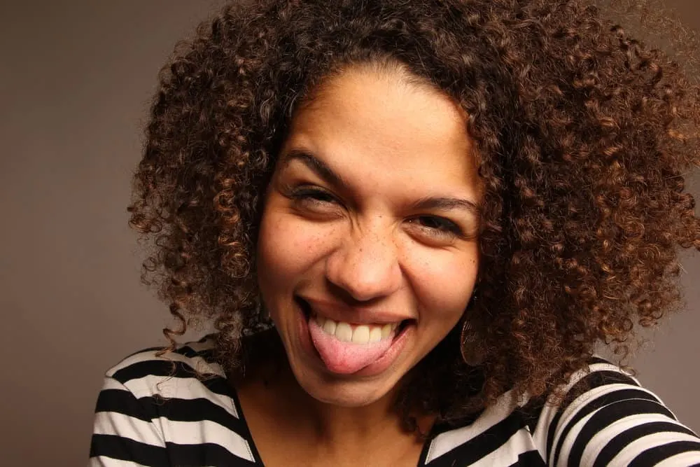 How Long Can You Keep Mixed Hair Dye? Can You Save Leftovers? 4 A black woman with medium brown natural hair, wearing semi-permanent hair color on her locks.