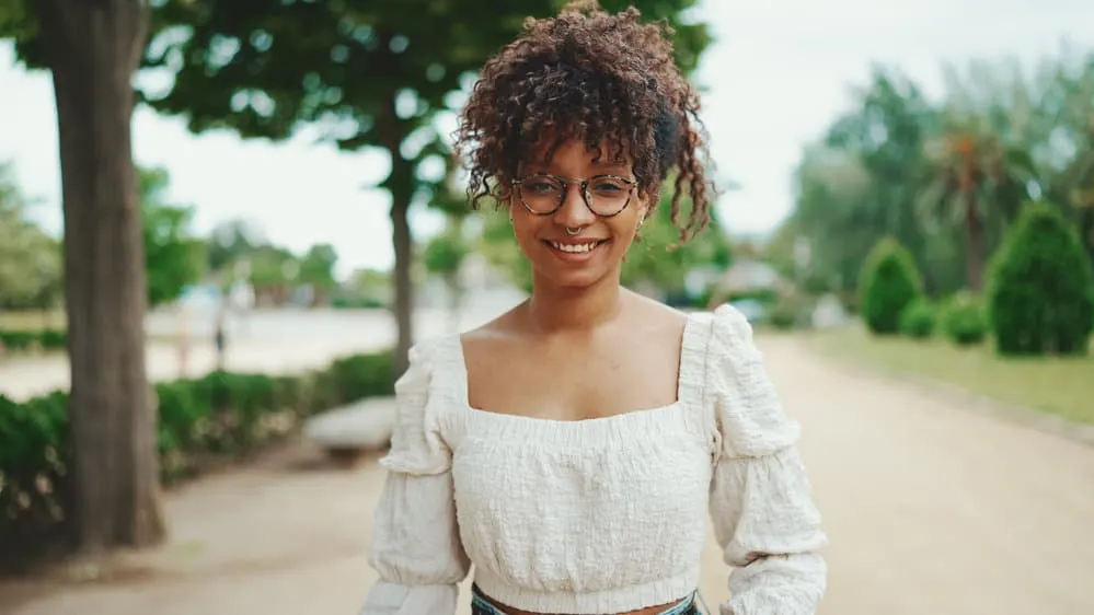 Young African American female with super frizzy curls with a little wave with black and brown highlights.