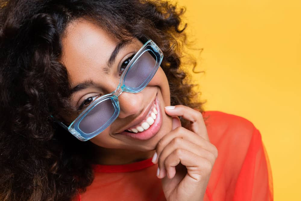 African American female with a medium-hair length has frizz-prone hair after using a hair dryer on her wet hair.