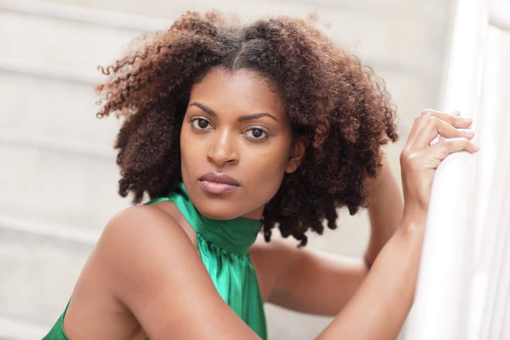 Light-skinned black lady wondering how fast the average person's hair grows after experiencing hair loss.