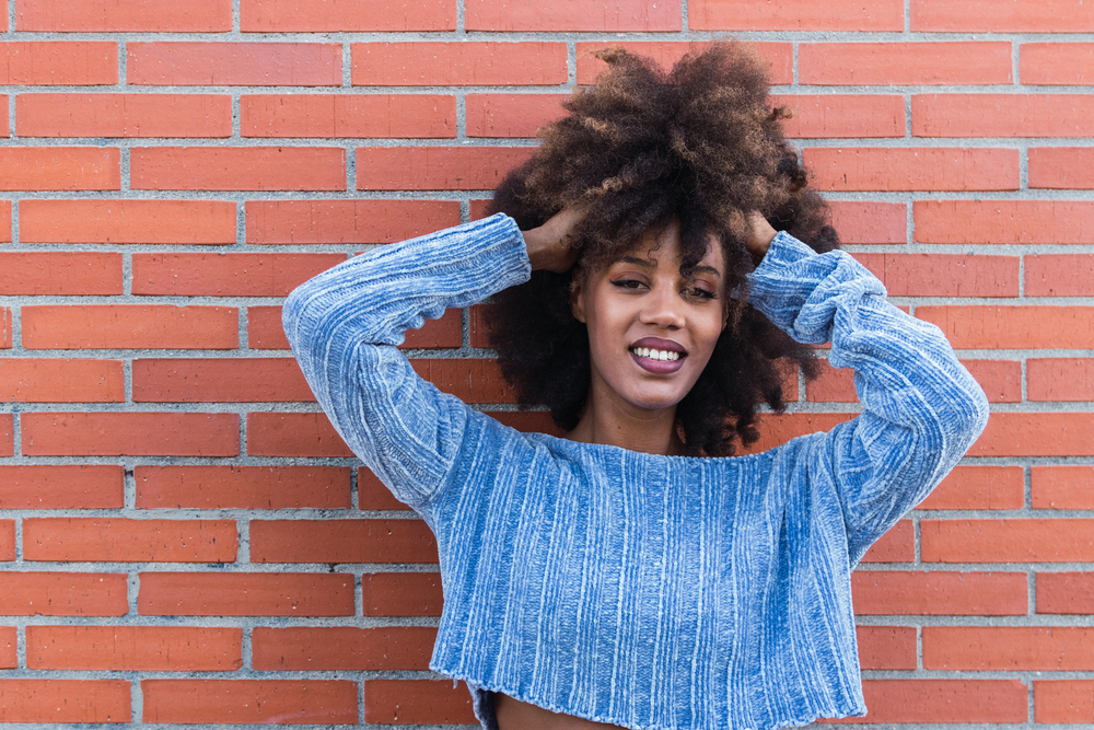 Attractive African American female with a coily hair type after using a rice water hair rinse from boiling rice.