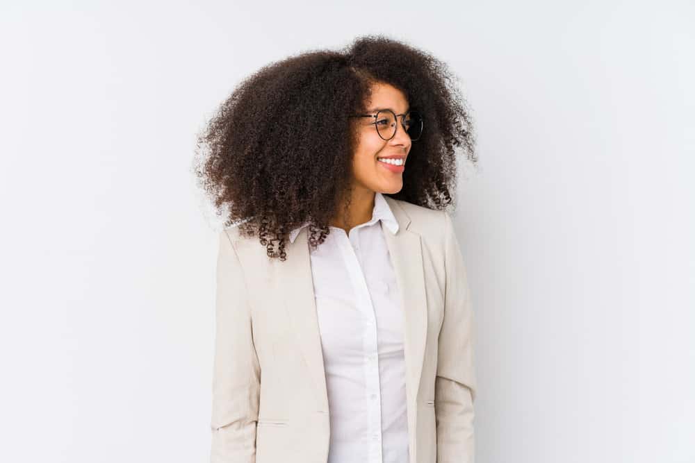 Black lady with kinky hair wearing long curls - one of our favorite natural hair styles for African American women.