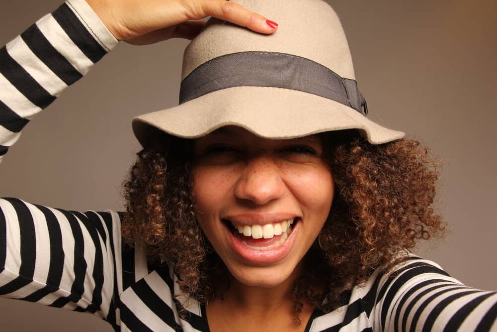 A cute mixed-race lady that lives in the warm and humid microclimate of Birmingham, Alabama wearing a stylish hat.