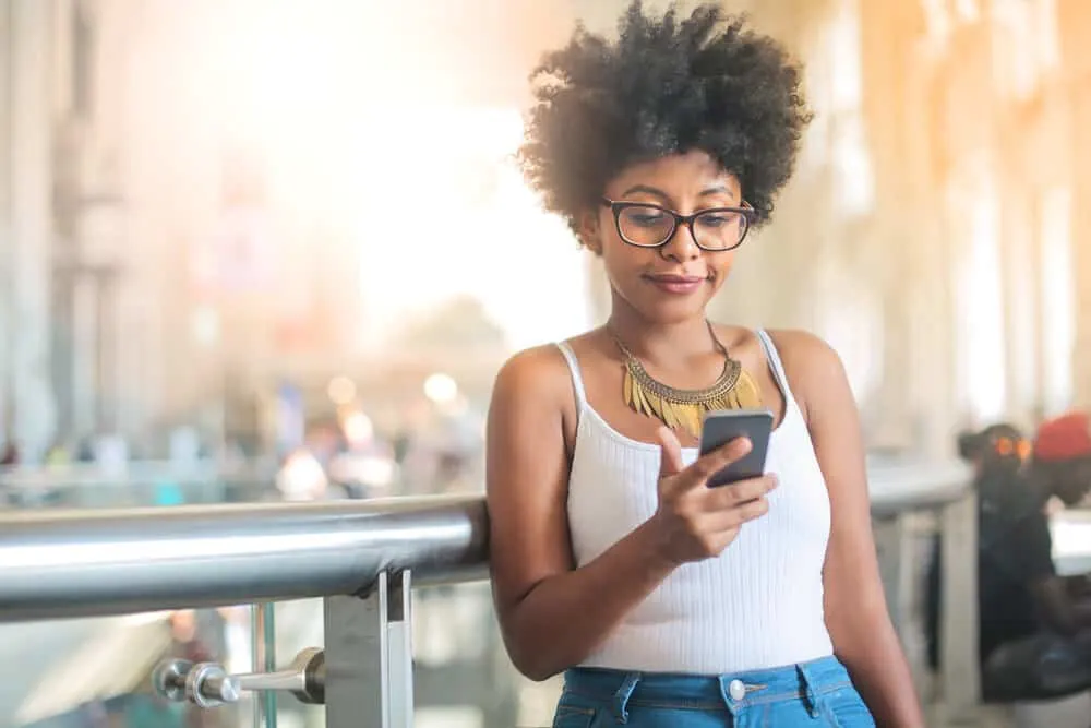Does Great Clips Dye Hair? Does Great Clips Bleach Hair? 4 A young black woman examines the services menu - Great Clips prices and compares them to other hair salons.