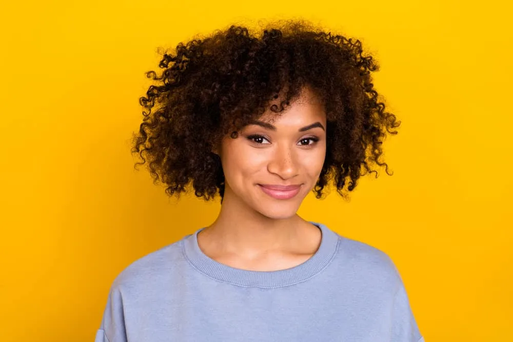 Cardi B Hair Mask: Recipe, Tutorial, Benefits, and More 5 African American female with coily hair strands conditioned with all the ingredients in Cardi's homemade hair mask.
