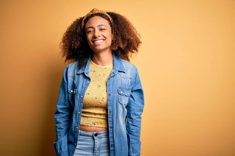 A confident black woman with healthy hair after using a color oops treatment to remove hair dye.