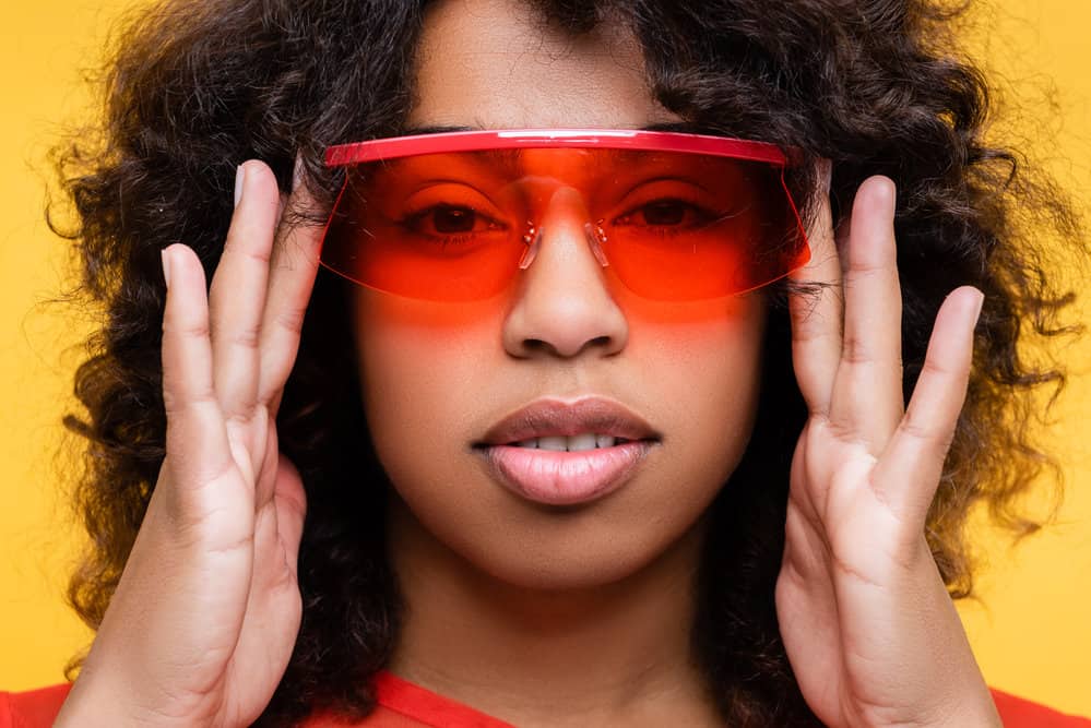 After using a hair dryer on wet black female hair, the African American woman with medium-hair length has frizz-prone hair.