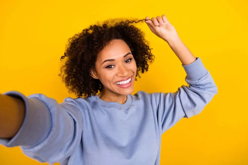 Cardi B Hair Mask: Recipe, Tutorial, Benefits, and More 7 Positive African lady wearing a wash-and-go hairstyle created with a natural castor oil mayo mixture.