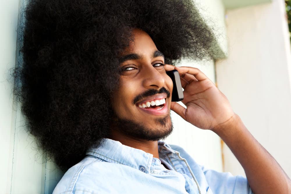 A young guy who's a metal head asking his girlfriend if she likes rock bands during a phone call.