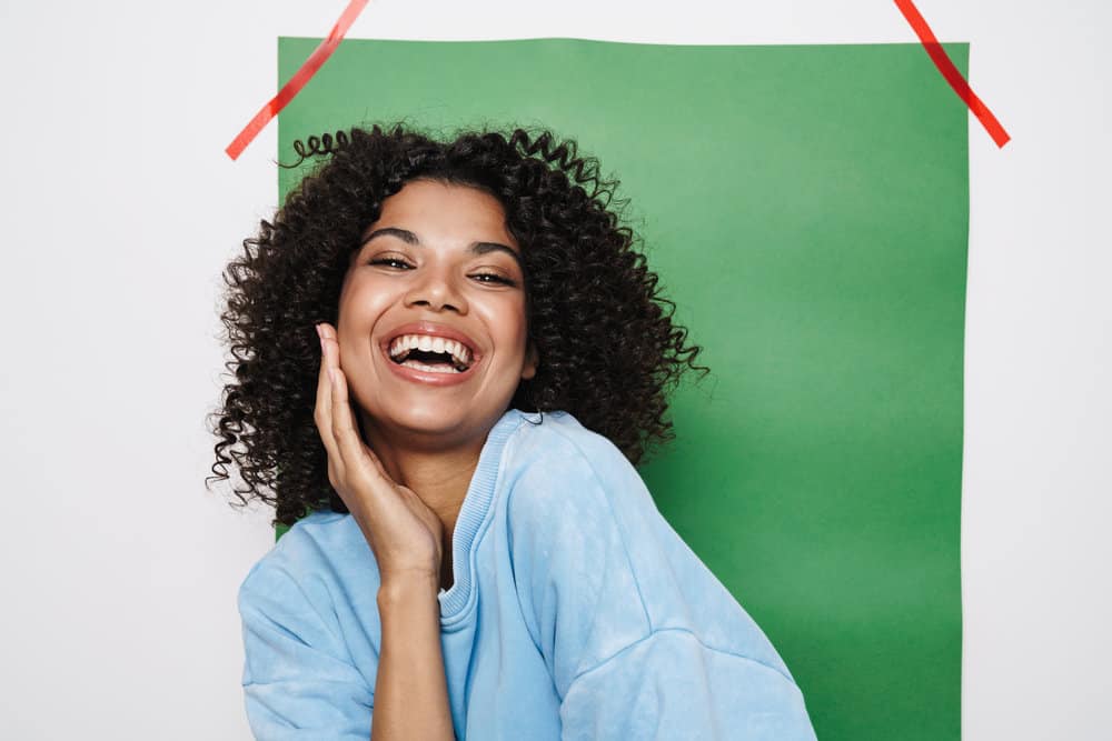 Before applying clarifying shampoo and conditioning hair mask, a black girl had dandruff had unruly hair follicles.