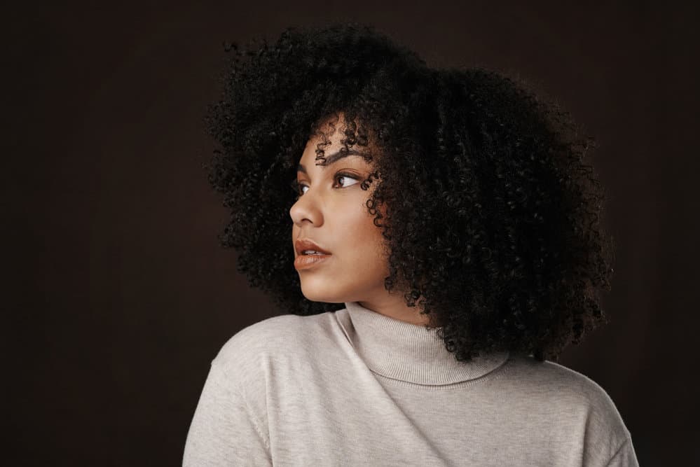 This lovely lady has short, wavy hair that she's brushed into a loose style with a wooden brush.