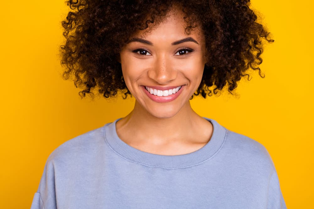 A pretty young American female wearing a good hair mask with nourishing ingredients like two avocados.