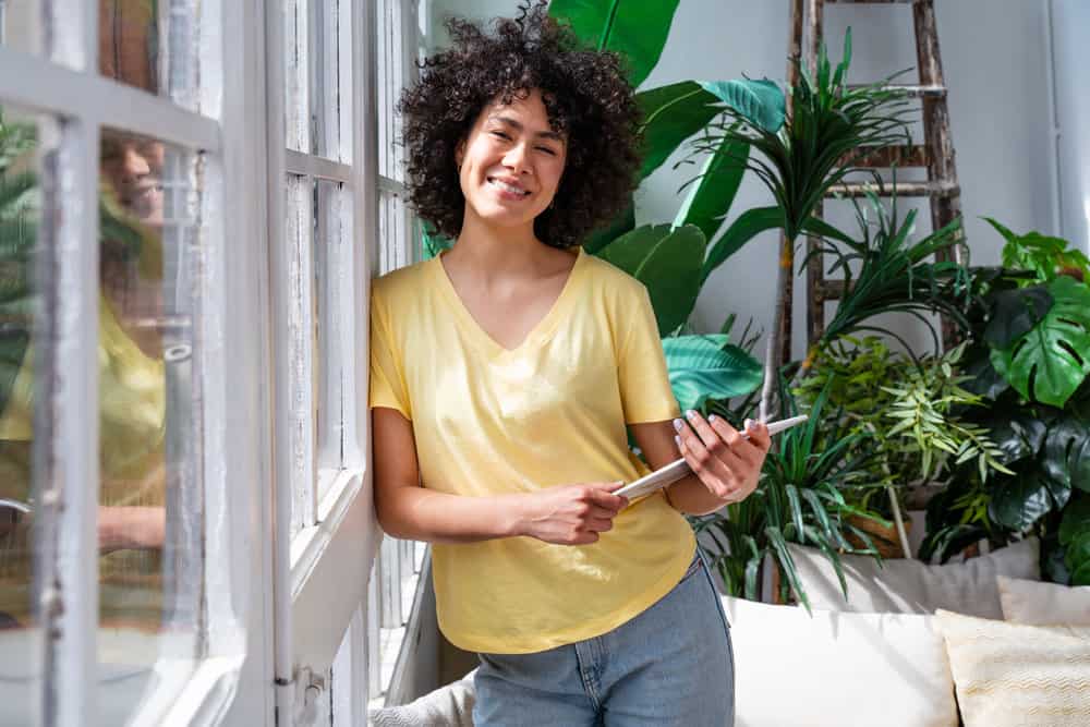 Pretty South American lady researching the hair health properties of using a half cup of washed rice water daily.