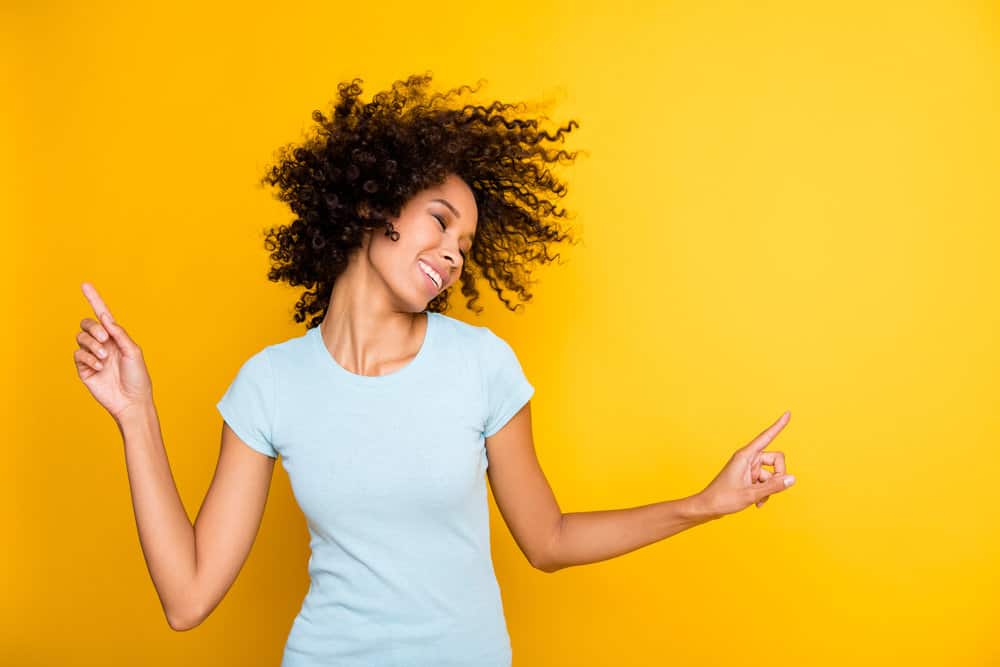 An adorable woman wearing semi-permanent color pigments on her dark brown naturally curly hair.