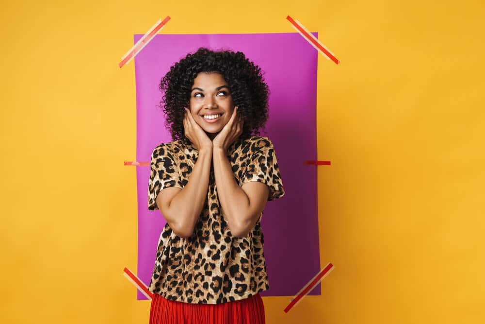 A young lady wearing a red skirt with an animal print t-shirt wearings clean curls washed with a mild shampoo.